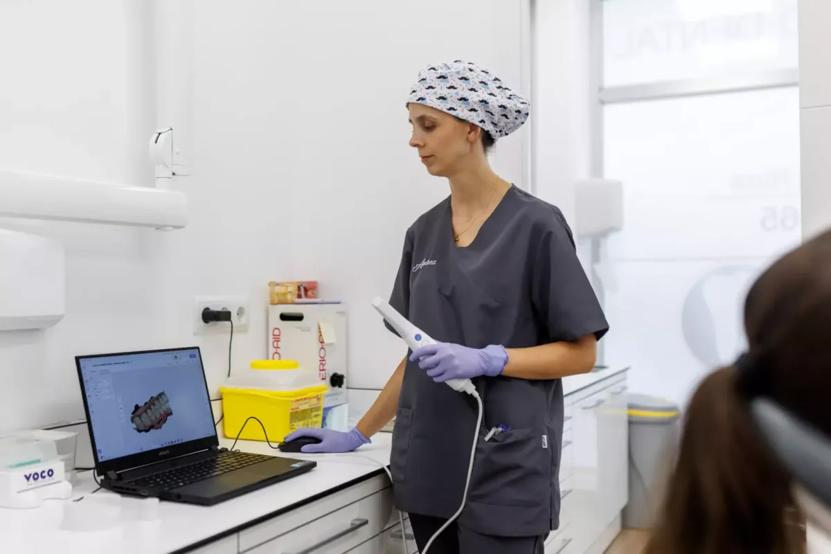 Andrea manejando un portátil en cuya pantalla se ve un modelo 3d de una boca